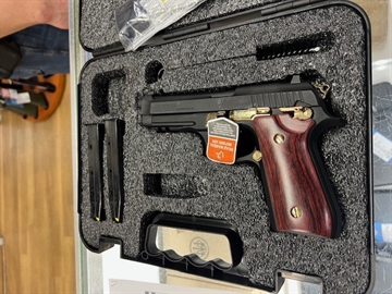 Picture of Taurus 1-920151GLD-HW1 92 Full Size Frame 9mm 17+1 5" Matte Black Stainless Steel Barrel, Matte Black Serrated Alloy Steel Slide, Matte Black w/Gold Accents Aluminum Frame w/Picatinny Rail, Wood Grip 1-920151GLD-HW1 1920151GLDHW1